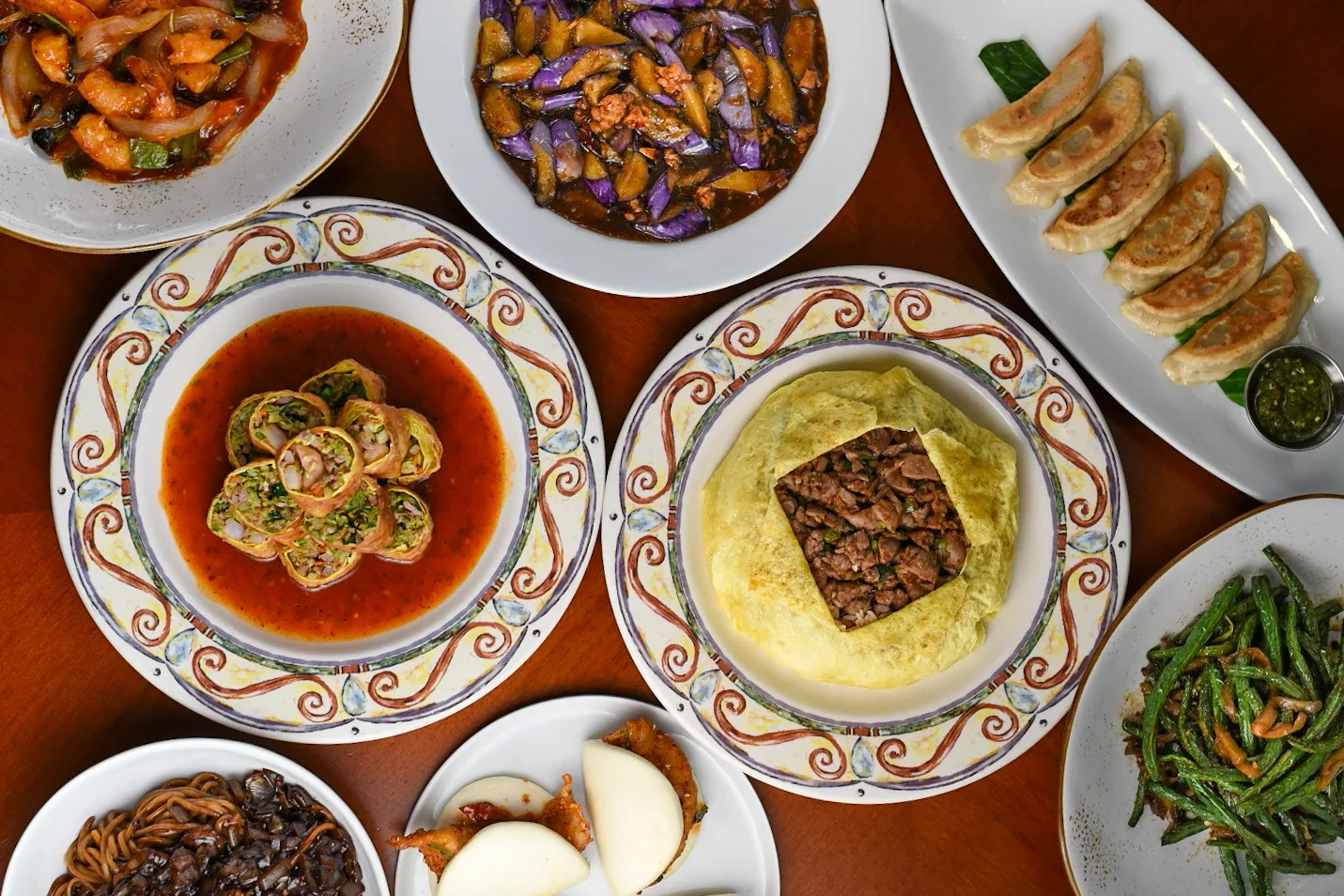 A spread of North China favorites — jajangmyeon, pot stickers, minced beef rice, eggplant and more — on the table in Houston